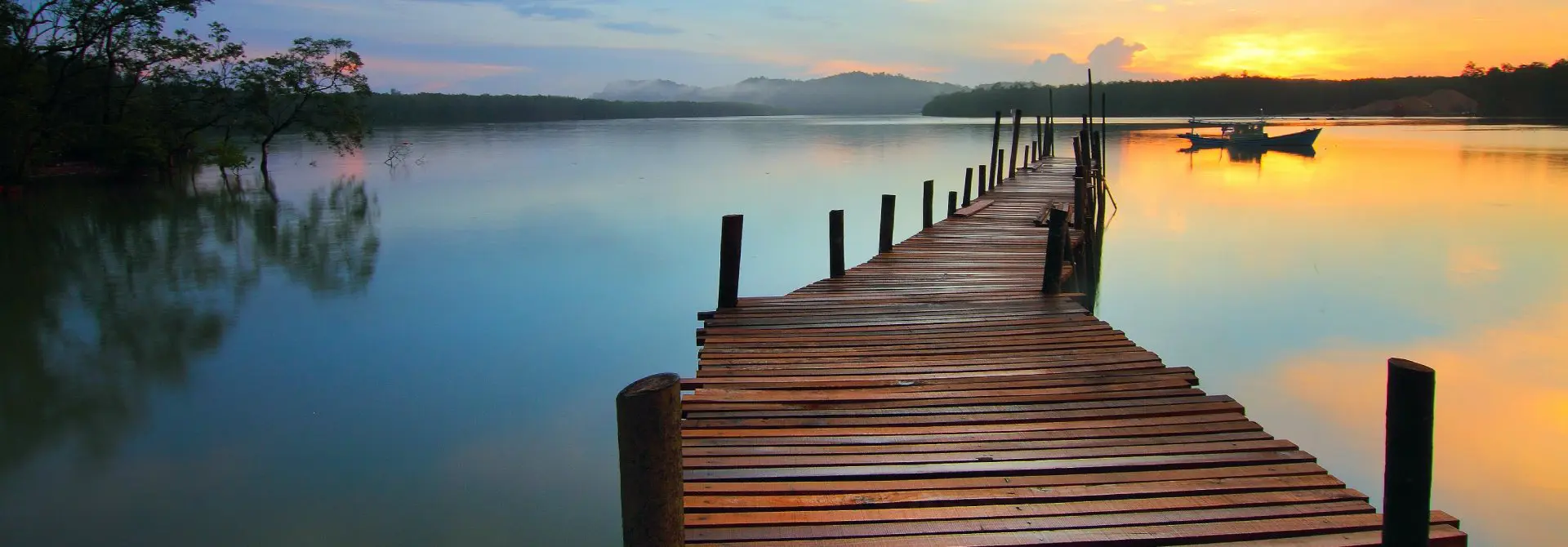 A dock with wooden posts and water in the background.